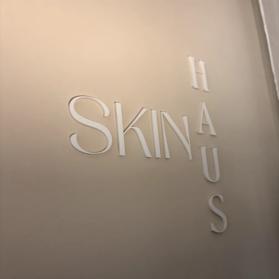 Logo SKINHAUS na stěně salonu